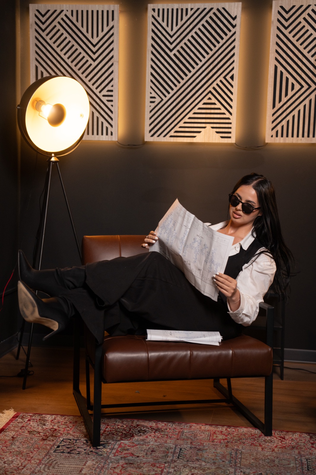 Studio Podcast — cadru editorial în fotoliu, cu lampa-disc în fundal